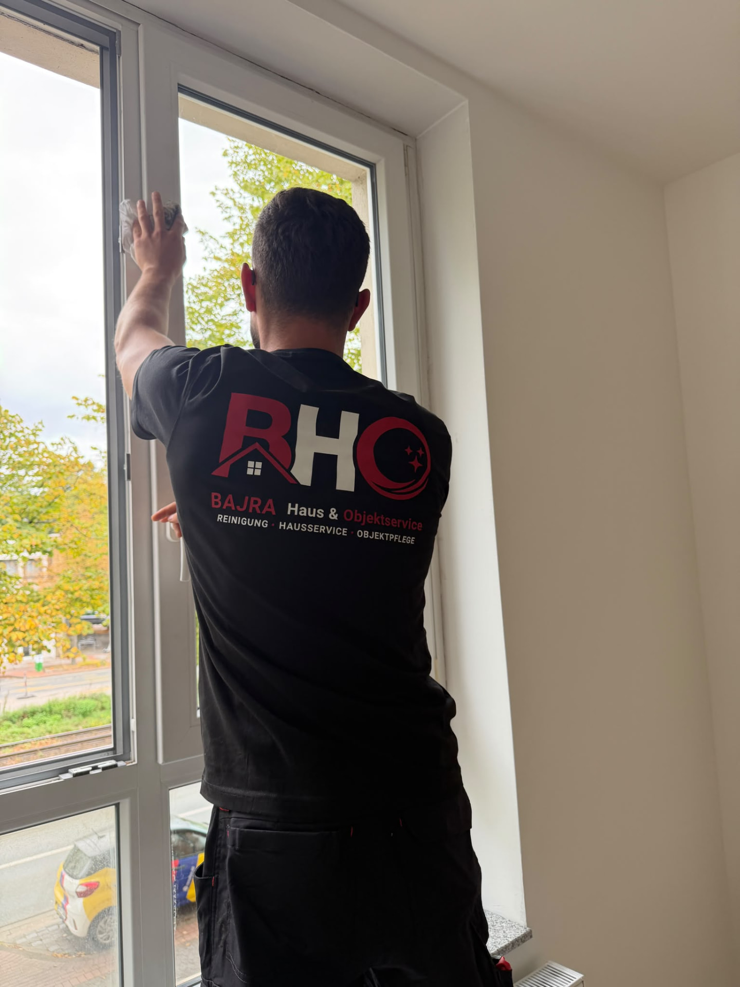 Mitarbeiter von BAJRA Haus & Objektservice reinigt ein Fenster in Barsinghausen